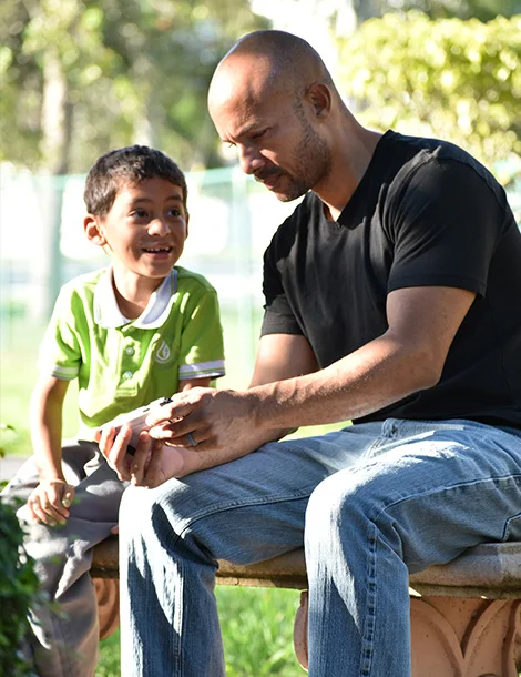 A man reading a passage from the Bible to a kid