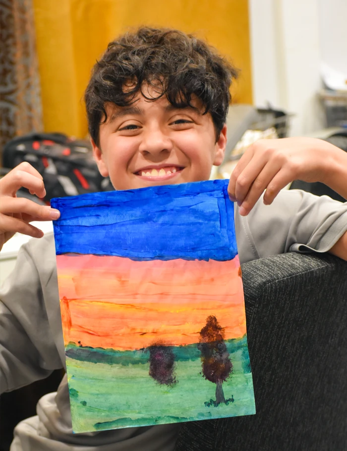 Pneuma middle school student showing his art and craft work